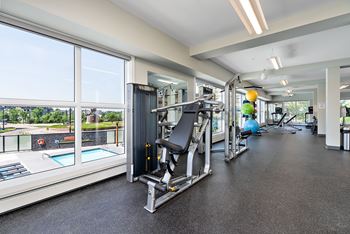 A gym with a view of a pool and trees.